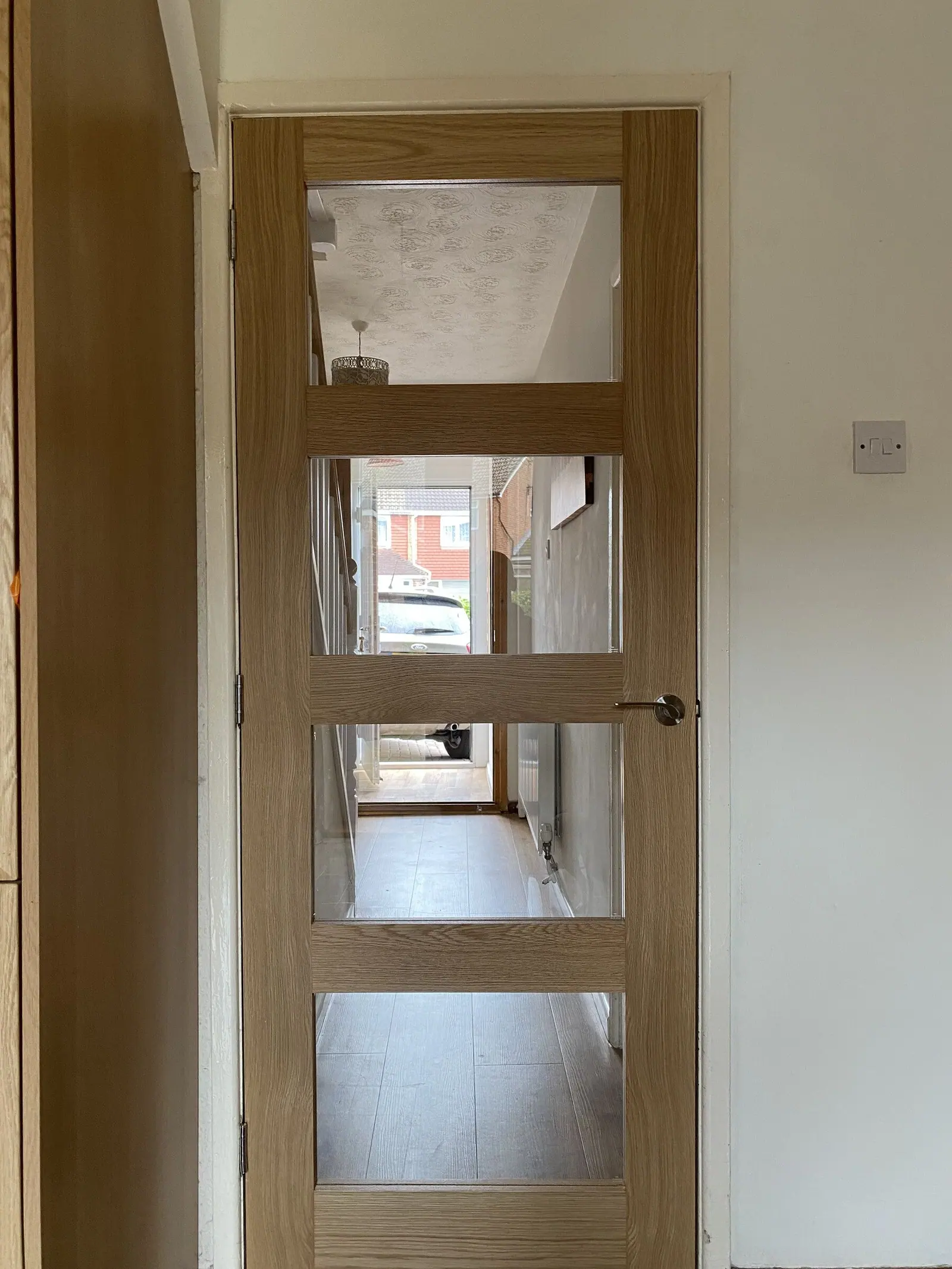 Oak four-light glazed internal door hung in a white-painted frame with brushed handle, fitted by Basingstoke Bathrooms